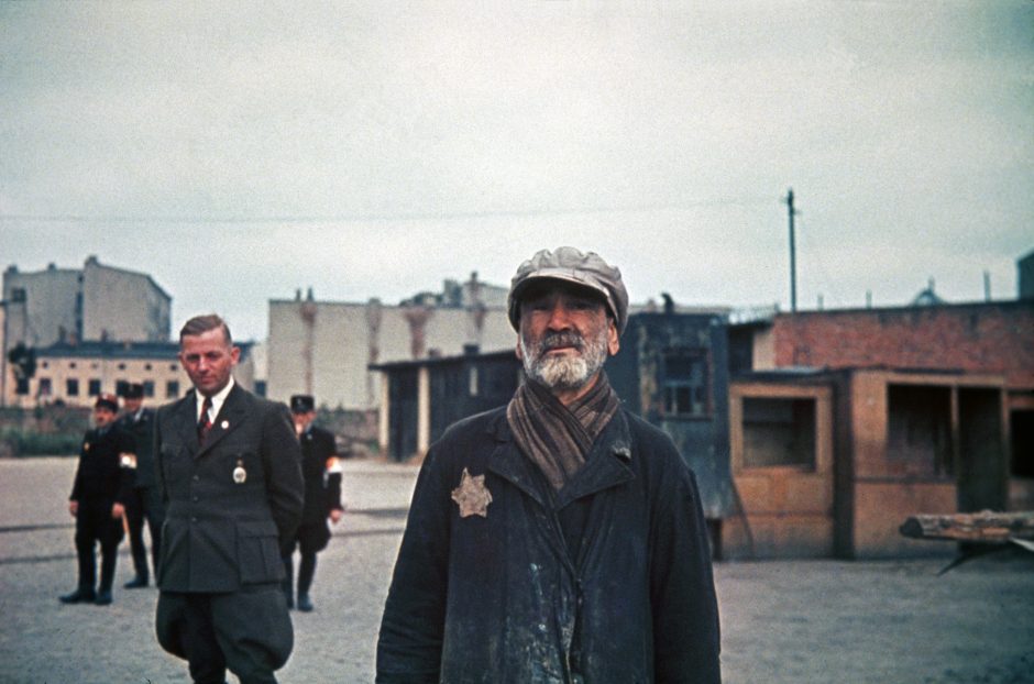 Hans Biebow, chief ofÊGerman Nazi administration of the ghetto and Jewish policemen watch an old jew.